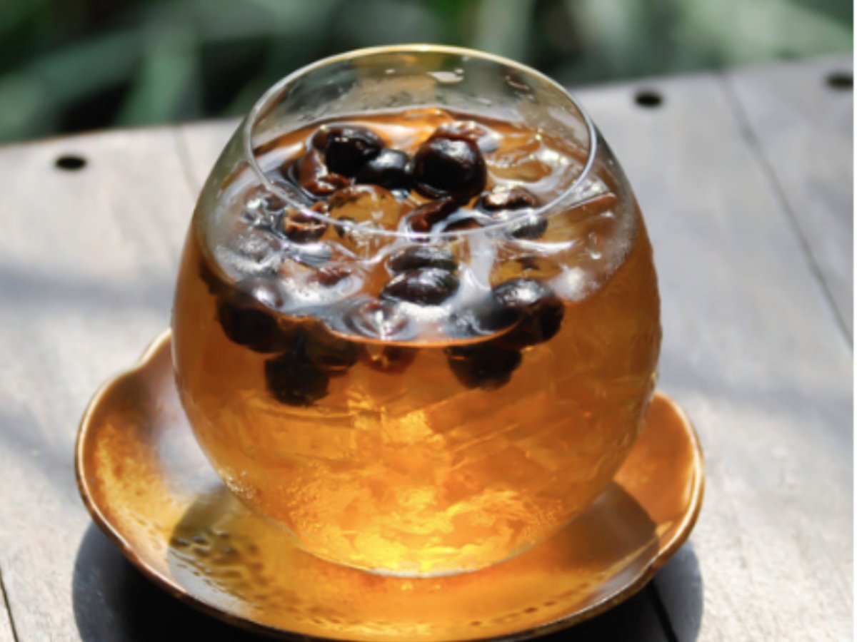 Cascara Cold Brew im Glas mit getrockneten Kaffeekirschen